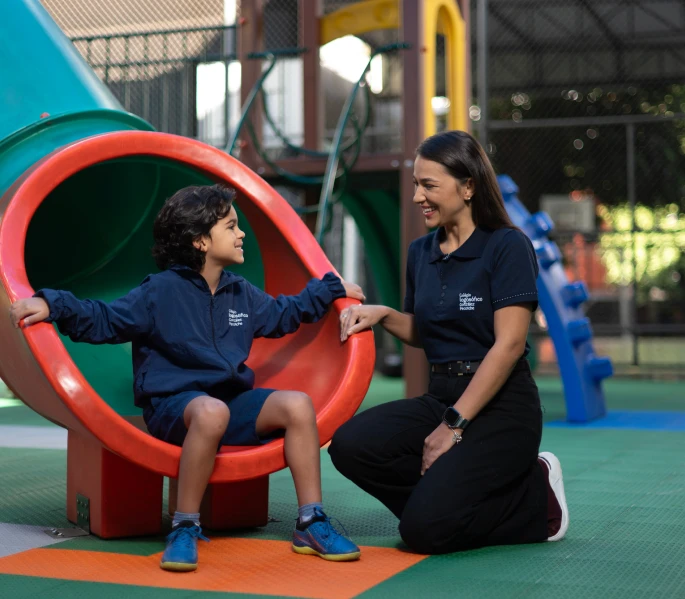 Professora e Aluno Conversando na ponta do escorregador